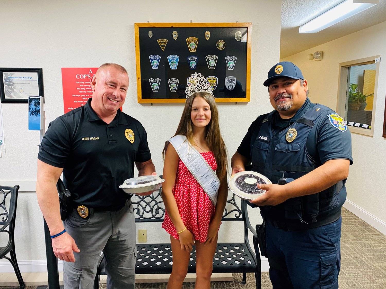 Thank you to Brooke Phillips "Jr. Miss Okeechobee" for treating the Okeechobee Police Officers to blueberry pies! Pictured with Brooke are Police Chief Donald Hagan (left) and Lt. Belen Reyna.